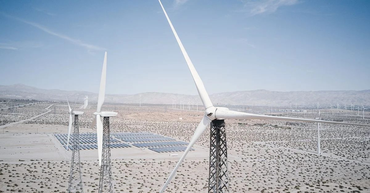Éoliennes et panneaux solaires produisant de l'énergie renouvelable dans un paysage désertique.