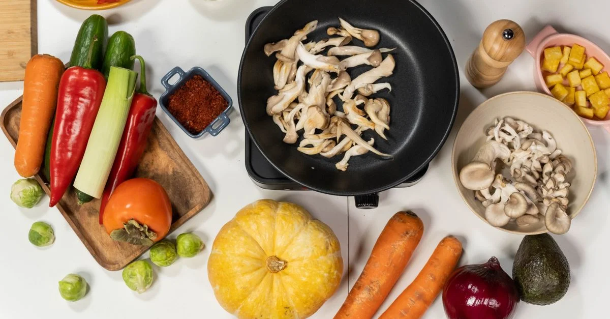 Vue de haut des légumes frais, champignons et ingrédients de cuisine sur un fond blanc, idéal pour des thèmes de cuisine et d'alimentation saine.